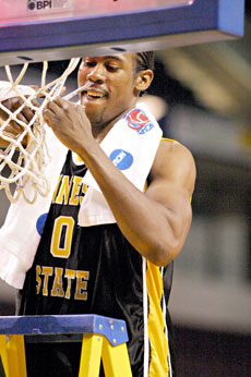 Reggie McKoy, a forward from the Kennesaw State Owls, takes part in the college basketball tradition of cutting down the net after winning the national championship.