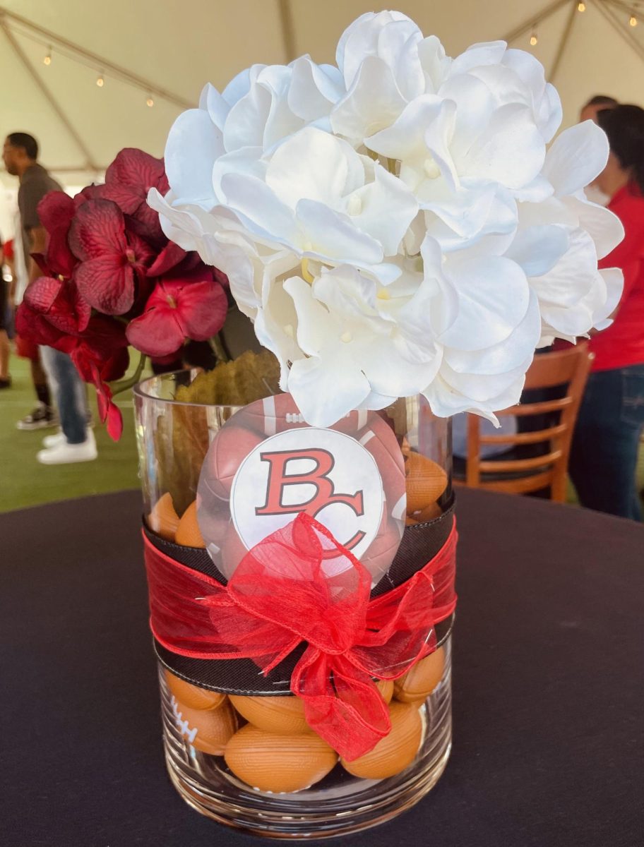 Centerpiece decorated with flowers and BC logo along with some mini footballs making a unique appearance.