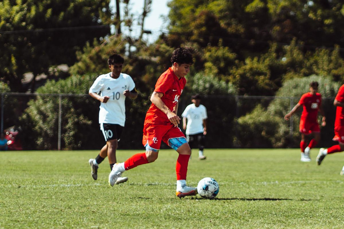 Defender Ricardo Morales (14) keeps the ball away from ELAC in their match on Sept. 10.