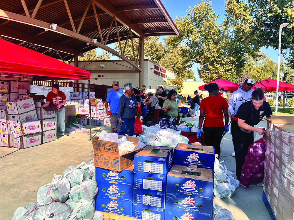 Volunteers helping the attendants to give them their fruits and vegetables.